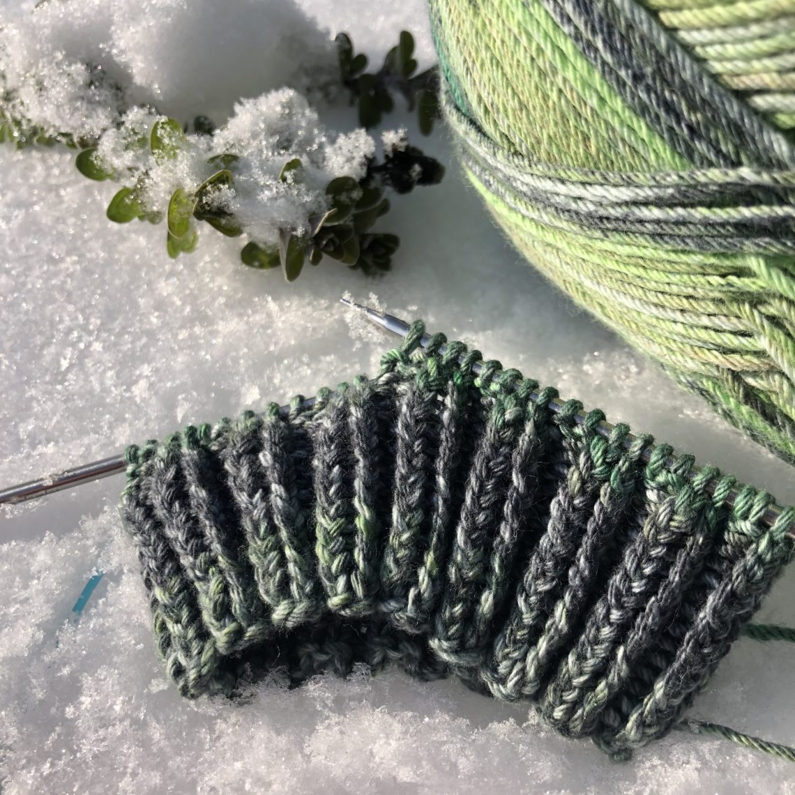 Grüne Socke Baumwollgarn im Schnee Stricksocke